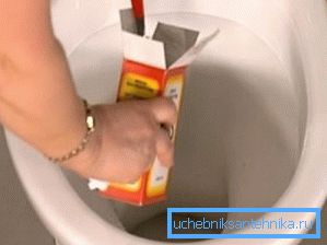 Zdjęcie zasypujące substancję w toalecie Zdjęcie zasypujące substancję w toalecie