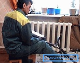 Na zdjęciu hydraulik myje grzejniki w mieszkaniu